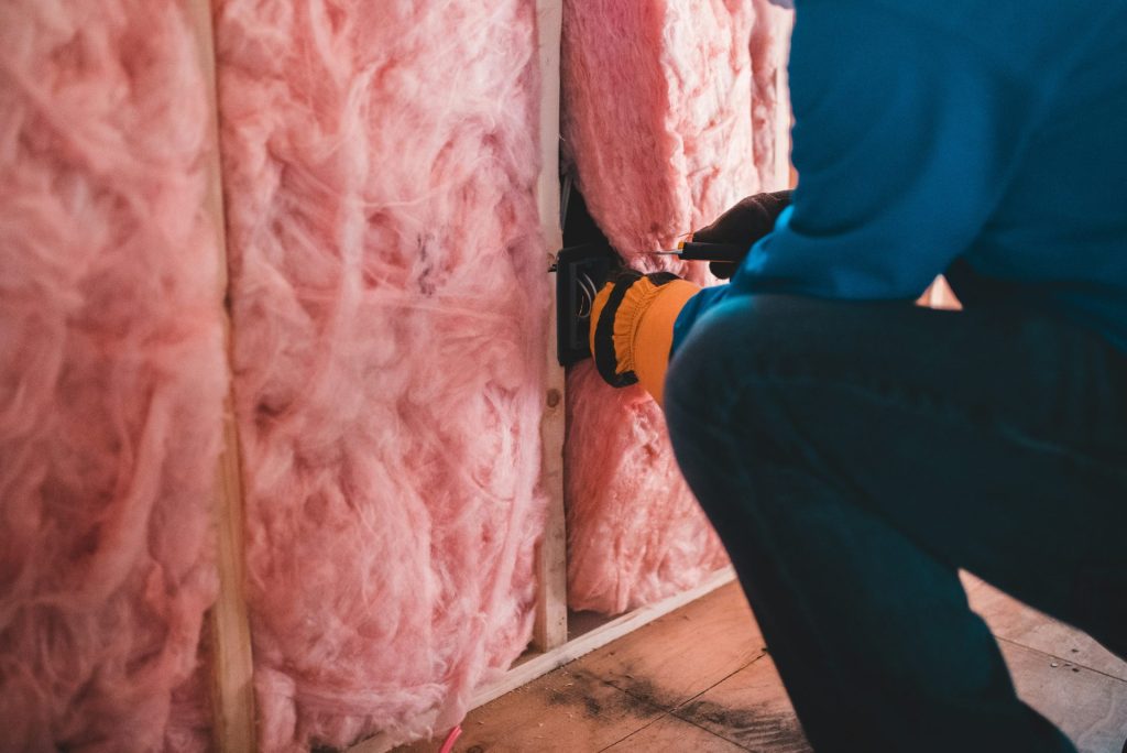 Persona instalando aislamiento rosado