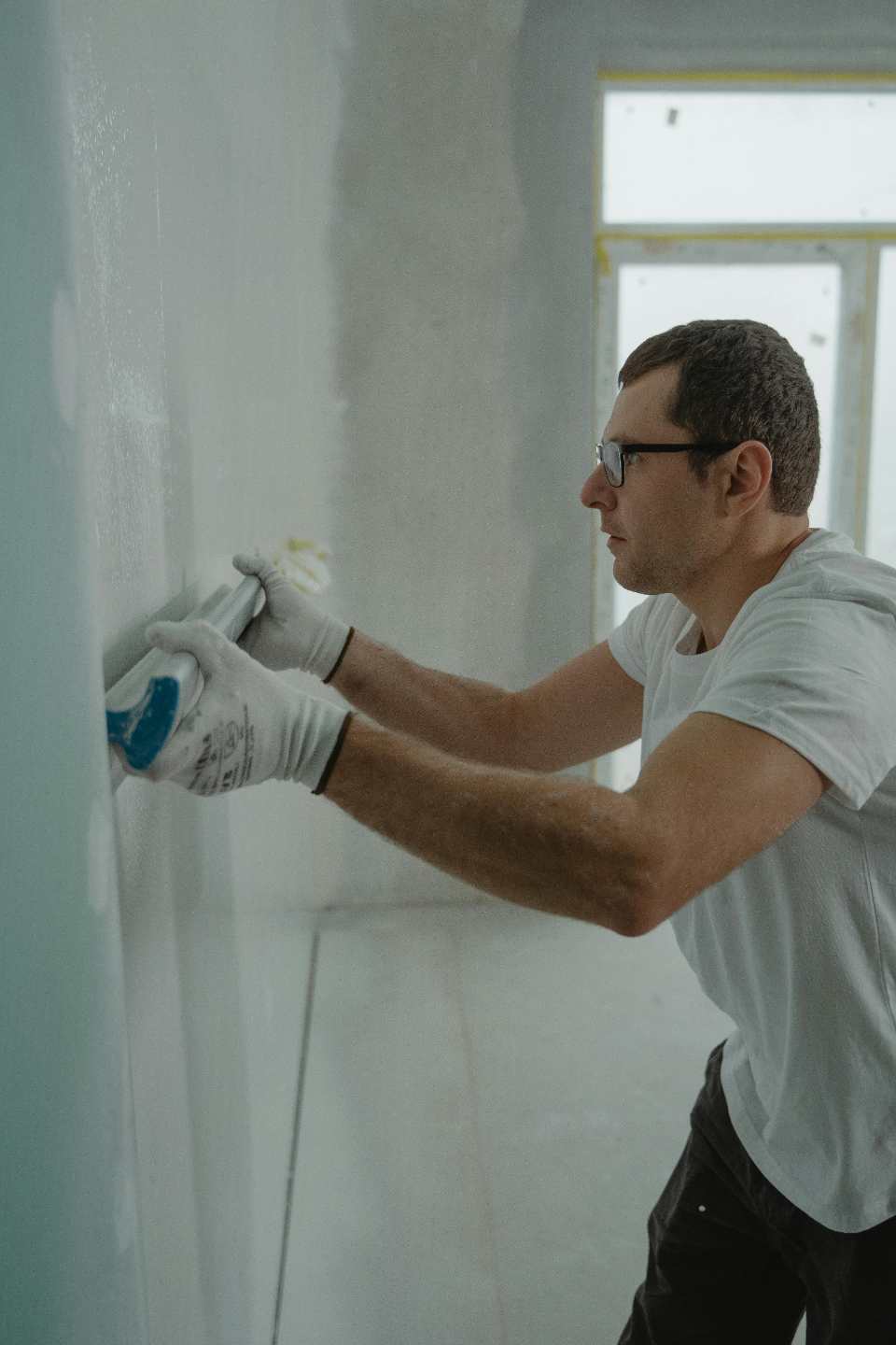 Hombre pasa una barra blanca por una pared